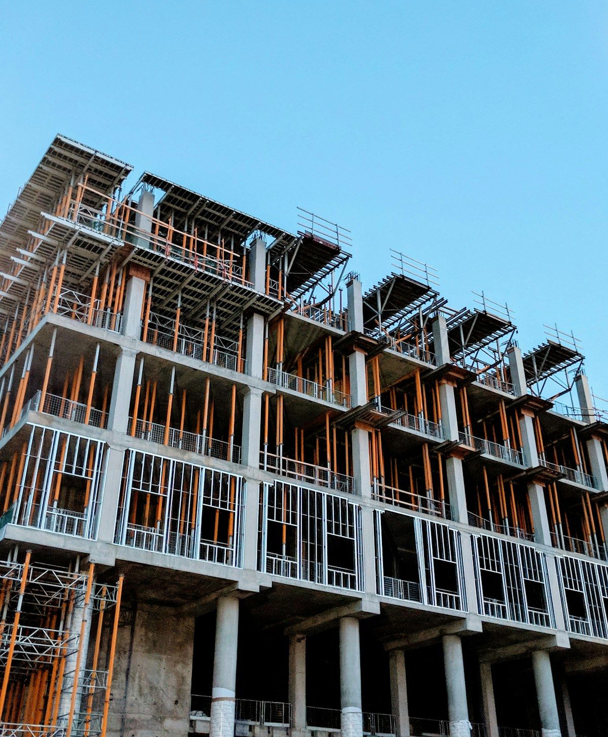 A construction site with concrete framing and scaffolding at dusk
