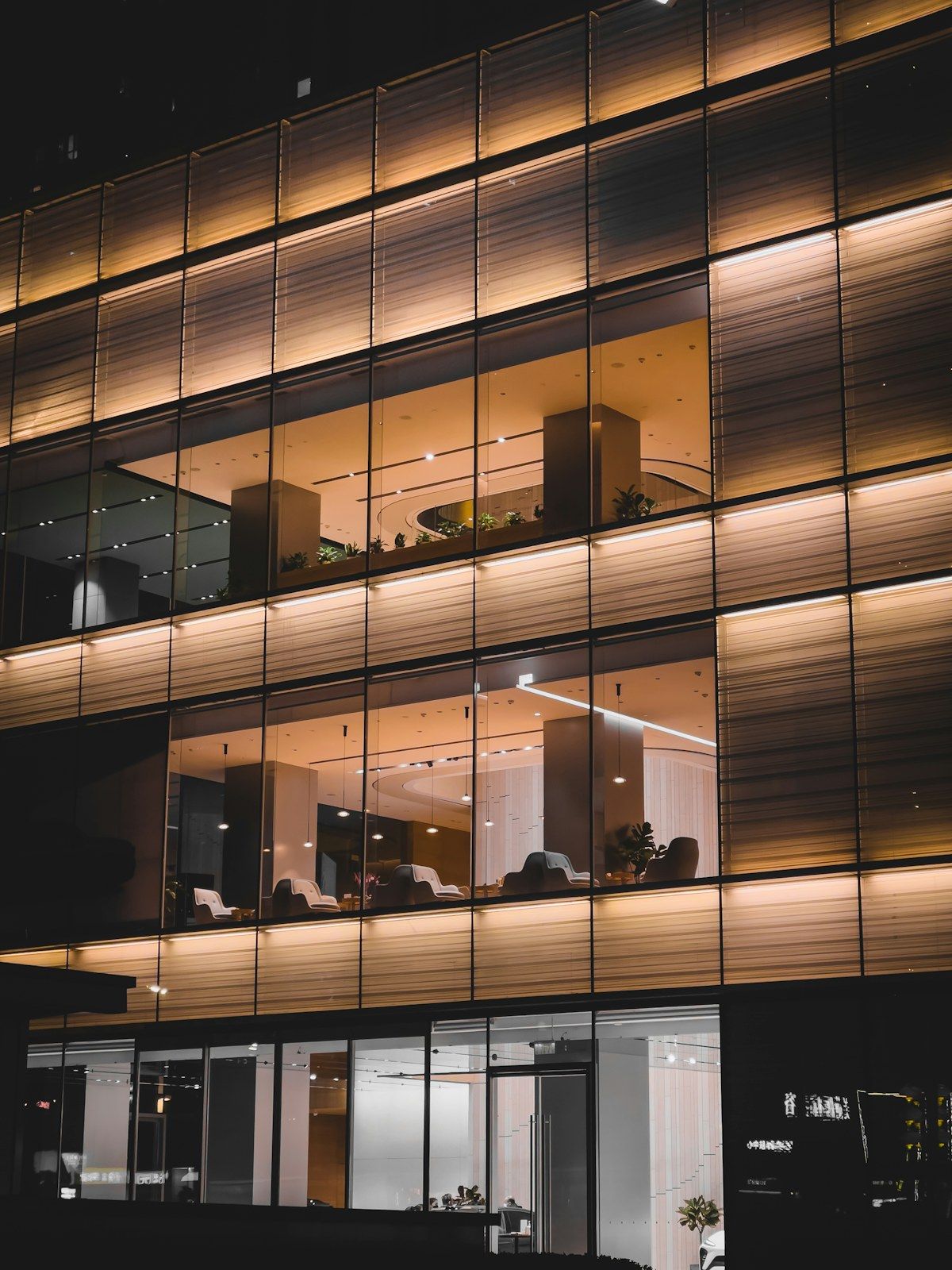 A commercial office building facade at night with lit windows